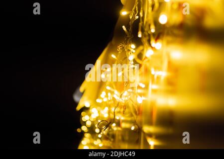 Weihnachtsdekoration - Girlande mit gelben Glühbirnen auf der Straße Nachts Stockfoto