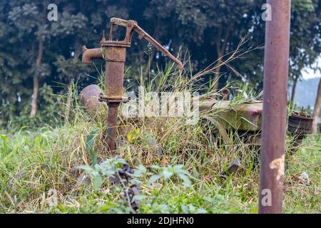 Nutzlose alte rostige Rohr gut mit einer Maschine in einem Ländliche Dorf, das für das Pumpen von Wasser in der verwendet wurde Reisfeld Stockfoto