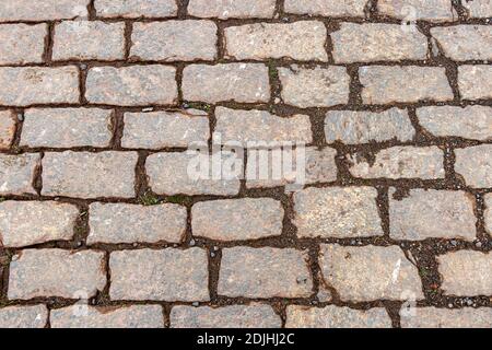 Alte, nasse Granitkopfsteingepflasterstraße Stockfoto