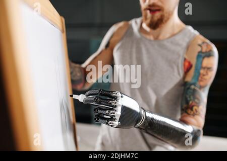 Bild eines Cyborg-Mannes mit bionischer Hand Ein Brett mit Permanentmarker Stockfoto