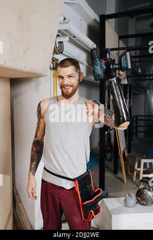 Glücklich zufrieden Cyborg Mann mit bionischen Hand posiert mit Elektro Schraubendreher Stockfoto