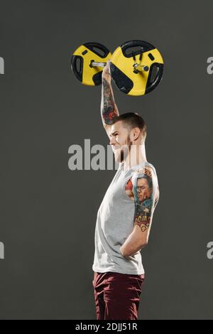 Hart arbeitender armlose Mann Heben einstellbare Hantel über Kopf mit einer Hand Stockfoto