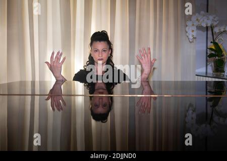 Elegant Italian Woman pianist showing hands above a black grand piano Stock Photo