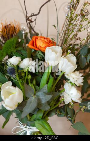 Schöne Designer luftigen Winter Blumenstrauß mit Weihnachtsdekorationen, close-up. Es besteht aus Eukalyptus, Ranunculus, Tulpen, Immortelle, Stockfoto