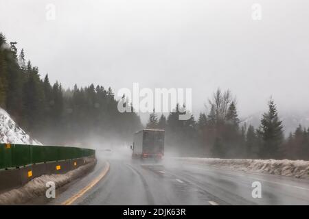 Semi Reisen entlang der I-90 östlich von Snoqualmie Pass während Regen und Schnee Bedingungen, Washington State, USA [Keine Eigentumsfreigabe; verfügbar für editori Stockfoto