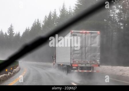 Semi Reisen entlang der I-90 östlich von Snoqualmie Pass während Regen und Schnee Bedingungen, Washington State, USA [Keine Eigentumsfreigabe; verfügbar für editori Stockfoto