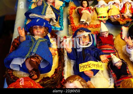 14. Dezember 2020, LA PAZ, BOLIVIEN: Eine Jesusbaby-Figur (auf Spanisch Niño genannt) für Krippen mit Gesichtsmaske und Schutzkleidung gegen das covid 19 Coronavirus auf einem Weihnachtsmarkt. Krippenbilder sind eine beliebte und wichtige Weihnachtsdekoration in Häusern und öffentlichen Plätzen in Lateinamerika und auch in Spanien (wo die Tradition herkommt). Auf den Weihnachtsmärkten werden zahlreiche Figuren für Krippen verkauft; niños der Schutz vor dem covid 19 Coronavirus ist in diesem Jahr neben traditionell gekleideten niños als Folge der Pandemie eine neue Option. Stockfoto