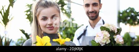 Besitzer von Blumenladen halten schöne blühende Zimmerpflanzen Stockfoto