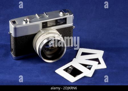 Alte Filmkamera mit Diafilm isoliert auf einem blauen Tischplatte Stockfoto