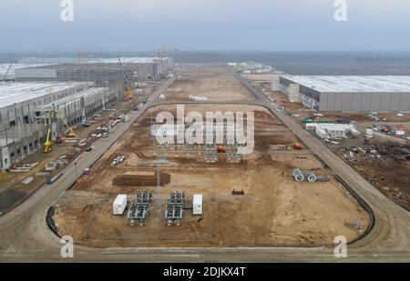 12. Dezember 2020, Brandenburg, Grünheide: Die Baustelle Tesla Gigafactory (Luftaufnahme mit Drohne). Ab Juli 2021 sollen im Werk maximal 500,000 Fahrzeuge pro Jahr vom Fließband Rollen - und nach den Plänen des Automobilherstellers soll das Maximum so schnell wie möglich erreicht werden. Der US-amerikanische Elektroauto-Hersteller erwartet, dass bis zu 10,500 Mitarbeiter in seinem geplanten ersten Werk in Europa zunächst Schichten arbeiten. Foto: Patrick Pleul/dpa-Zentralbild/ZB Stockfoto