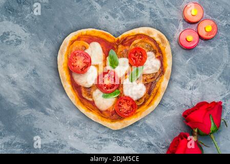 Herzförmige Pizza für einen besonderen Abend Stockfoto