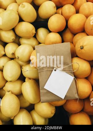 Bunte Geschenk Lieferung Parsel auf gelb und orange strukturierte Zitrushintergrund. Weihnachtliche Illustration mit leerem Etikett für Text- und Designkopie Stockfoto