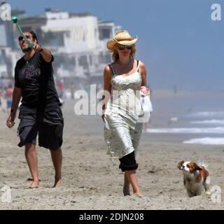 Rosanna Arquette macht einen Spaziergang am Strand mit einem Freund, während mit einigen Hunden holen spielen. Vielleicht ist die Schauspielerin müllbewusst, da sie einen mit Sand gefüllten Kanister Joghurt wegschmissen scheint. Malibu, Kalifornien, 9/06 Stockfoto