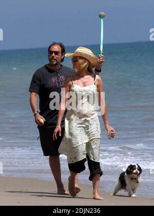 Rosanna Arquette macht einen Spaziergang am Strand mit einem Freund, während mit einigen Hunden holen spielen. Vielleicht ist die Schauspielerin müllbewusst, da sie einen mit Sand gefüllten Kanister Joghurt wegschmissen scheint. Malibu, Kalifornien, 9/06 Stockfoto