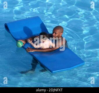 Exklusiv!! Frankreich und Arsenal Fußball-Ass Thierry Henry gibt Tochter Tee einige Lektionen in Schwimmen und Ballkontrolle. Frau Nicole Merry, die den Morgen mit Sonnenbaden verbrachte, schaute auf und wie jede stolze Mutter mit ihrer Digitalkamera wegschnappte. Am Morgen sonbte Nicole jeden Tag eineinhalb Stunden lang solo, während sie auf ihrem Mobiltelefon plauderte, non-stop, Miami Beach, FL, 7/25/06 Stockfoto