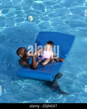 Exklusiv!! Frankreich und Arsenal Fußball-Ass Thierry Henry gibt Tochter Tee einige Lektionen in Schwimmen und Ballkontrolle. Frau Nicole Merry, die den Morgen mit Sonnenbaden verbrachte, schaute auf und wie jede stolze Mutter mit ihrer Digitalkamera wegschnappte. Am Morgen sonbte Nicole jeden Tag eineinhalb Stunden lang solo, während sie auf ihrem Mobiltelefon plauderte, non-stop, Miami Beach, FL, 7/25/06 Stockfoto
