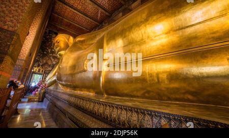 Goldene Statue des Reclining Buddha im Wat Pho Buddhist Temple Complex im Phra Nakhon District, Bangkok, Thailand. Religiöses Denkmal, Tourist A Stockfoto