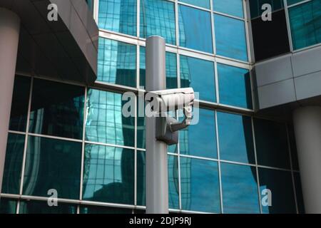 Externe Überwachungskamera gegen Glasfassade Stockfoto