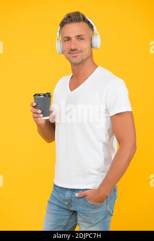 Kaffee zum Mitnehmen zu trinken ist eine Lebensart. Moderner Mann trinkt Kaffee und hört Musik. Take-away und Cafe mit Abholservice. Heißgetränk. Nur zum Mitnehmen. Stockfoto