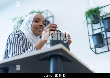 Junge muslimische afroamerikanische Geschäftsfrau als Führungskraft bei der Arbeit. Teamarbeit und multiethnisches Konzept. Glückliches, erfolgreiches Geschäft. Manager, Führungskraft. Stockfoto