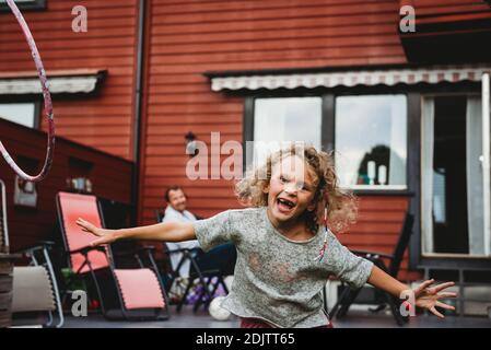 Mädchen mit großen Lächeln fehlt Vorderzähne mit Spaß in Garten im Sommer Stockfoto