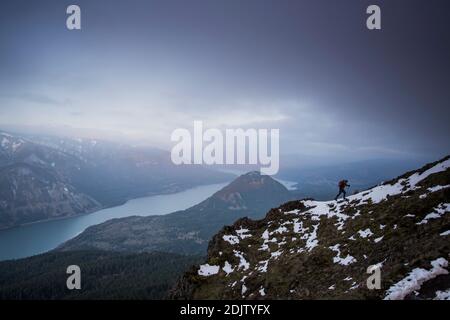 Ein junger Mann klettert auf Dog Mountain mit Blick auf die Columbia Gorge. Stockfoto