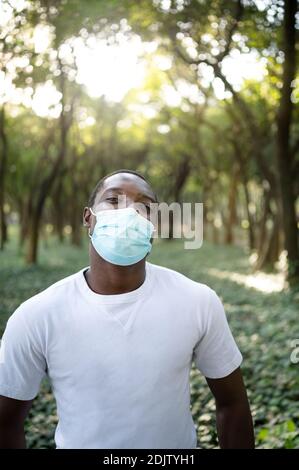 Ein junger schwarzer Mann mit einer Maske in der covid-19 Pandemie-Saison. Stockfoto