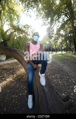 Ein junger schwarzer Mann mit einer Maske in der covid-19 Pandemie-Saison. Stockfoto