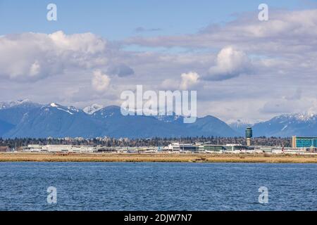 RICHMOND, KANADA - 05. APRIL 2020: Vancouver International Airport YVR mit den Coast Mountains im Hintergrund und dem Fraser River im Vordergrund Stockfoto