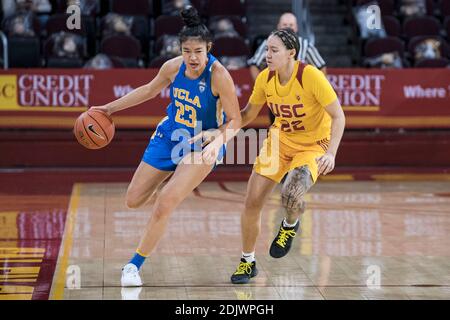 UCLA Bruins guard Natalie Chou (23) is defended by Southern California Trojans guard Kyra White (22) during an NCAA college basketball game, Sunday. D Stock Photo