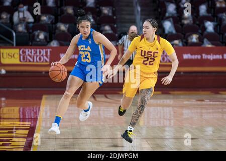 UCLA Bruins guard Natalie Chou (23) is defended by Southern California Trojans guard Kyra White (22) during an NCAA college basketball game, Sunday. D Stock Photo