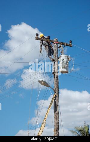 Eine vertikale Aufnahme von elektrischen Lineman arbeiten auf Mast Stockfoto