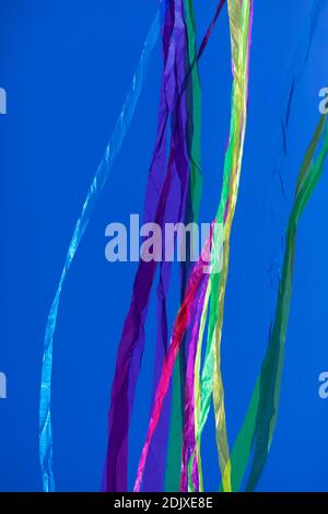 Regenbögen mit abstrakten, beweglichen Linien, in lebendigen Farben, geformt von zerknittert Stoffen, die leicht auf einem einfarbigen Hintergrund schweben. Stockfoto