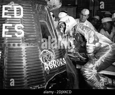 Astronaut Scott Carpenter looks inside the Aurora 7 spacecraft prior to insertion. McDonnell and NASA capsule technicians along with Astronaut Wally Schirra and John Glenn watch Carpenter prepare for his programmed three-orbit mission at Cape Canaveral, Florida, May 24, 1962. Photo by NASA via CNP/ABACAPRESS.COM Stock Photo