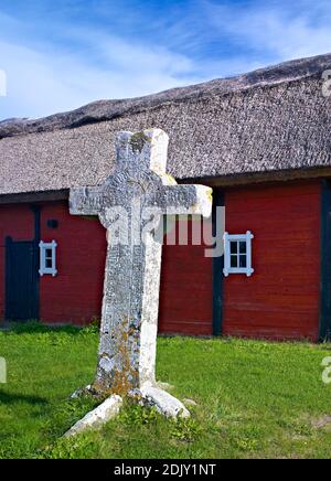 Europa, Schweden, Smaland, Insel Öland, Steinkreuz (Martinus Kreuz) bei Föra (15. Jahrhundert), Bauernhof mit Strohdach Stockfoto