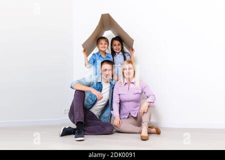 Glückliche Familie spielt in neue Heimat. Vater, Mutter und Kind haben Spaß zusammen. Umzugshaus Tag und Immobilien-Konzept Stockfoto