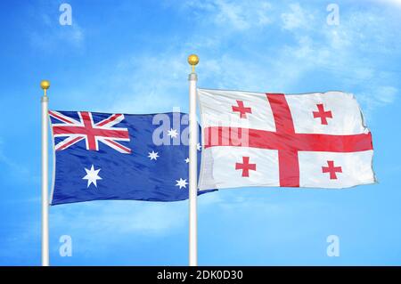 Australien und Georgien zwei Flaggen auf Fahnenmasten und blau bewölkt Himmel Stockfoto