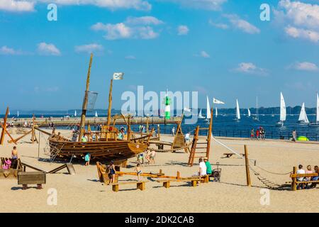 Deutschland, Schleswig-Holstein, Lübeck Buch, Ostseebad Travemünde, Blick von der Promenade auf den Spielplatz am Strand, im Hintergrund die Nordermole mit dem kleinen Leuchtturm Stockfoto