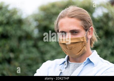 Junger Mann mit Mund- und Nasenmaske, Portrait Stockfoto