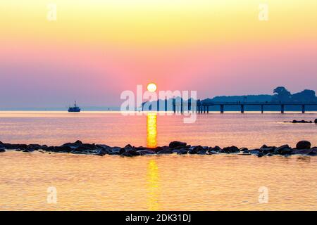 Deutschland, Schleswig-Holstein, Niendorf, Sonnenaufgang am Meer, Blick auf die Seebrücke und das Brodtener Ufer, Stockfoto