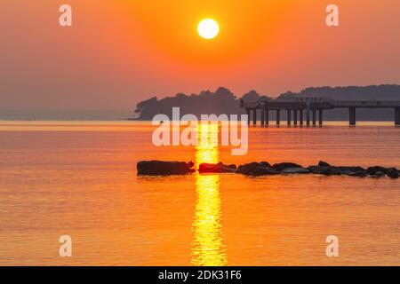 Deutschland, Schleswig-Holstein, Niendorf, Sonnenaufgang am Meer, Blick auf die Seebrücke und das Brodtener Ufer, Stockfoto