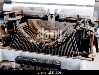 Kaputte Schreibmaschine aus Metall. Vintage-Objekt. Buchstaben ragen heraus. Stockfoto