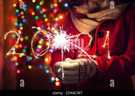 Frau mit bengalischen Lichter über bokeh Hintergrund. Weihnachten Konzept. Stockfoto