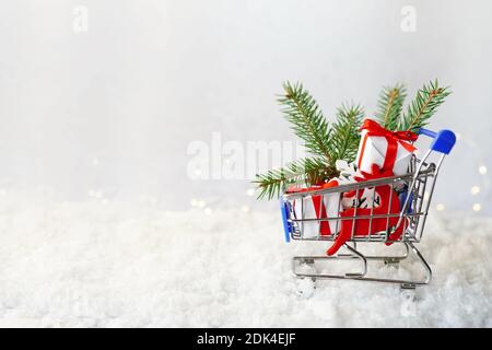 Warenkorb voller Weihnachtsgeschenke auf Schnee, Hintergrund mit Kopierplatz Stockfoto