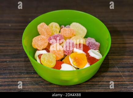 Ein High-Angle-Schuss von bunten Obst Süßigkeiten Gummi-Mix In einer Kunststoffschüssel im weichen Fokus Stockfoto