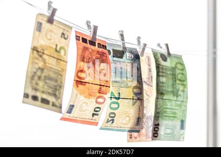 Ein Euro-Geldschein aus Papier hängt an einem Seil mit einer Wäscheklammer auf dem Hintergrund des Fensters. Stockfoto