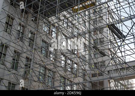 Baustelle des Gebäudes. Umfangreiche Gerüste, die Plattformen für die laufenden Arbeiten an einem hohen Gebäude im Bau mit Gerüsten bieten. Stockfoto