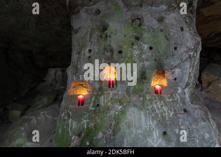 13. Dezember 2020, Sachsen-Anhalt, Langenstein: Drei rote Kerzen brennen in einer Sandsteinhöhle. In Langenstein im Harz wartet man förmlich darauf, dass eine Hobbit-Pfeife um die Ecke raucht. In der kleinen Stadt bei Halberstadt gibt es noch ein Dutzend gut erhaltene Höhlenwohnungen, die an die Aue der beiden Bestseller "der Herr der Ringe" und "der Hobbit" des Schriftstellers J.R.R. erinnern Tolkien. Die Behausungen wurden von Bauernfamilien ab 1855 mit Hammer und Meißel in mehrere Sandsteinfelsen gehauen. Heute kümmert sich ein Verein um die PR Stockfoto