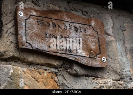 13. Dezember 2020, Sachsen-Anhalt, Langenstein: "Höhlenwohnung - bewohnt bis 1916" steht am Eingang zu einer der kleinen Höhlenwohnungen. In Langenstein im Harz wartet man förmlich darauf, dass eine Hobbit-Pfeife um die Ecke kommt. In dem kleinen Dorf bei Halberstadt gibt es noch ein Dutzend gut erhaltene Höhlenwohnungen, die an die Aue der beiden Bestseller "der Herr der Ringe" und "der Hobbit" des Schriftstellers J.R.R. erinnern Tolkien. Die Behausungen wurden von Bauernfamilien ab 1855 mit Hammer und Meißel in mehrere Sandsteinfelsen gehauen. Toda Stockfoto