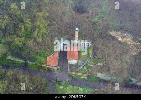 13. Dezember 2020, Sachsen-Anhalt, Langenstein: Blick auf eine Höhlenwohnung in Langenstein. In diesem Dorf im Harz warten Sie auf eine Hobbit-Pfeife, die um die Ecke kommt. Hier gibt es noch ein Dutzend gut erhaltene Höhlenwohnungen, die an die Aue der Bestseller 'der Herr der Ringe' und 'der Hobbit' des Schriftstellers J.R.R. erinnern Tolkien. Die Wohnungen wurden von Bauernfamilien ab 1855 mit Hammer und Meißel in Sandsteinfelsen gehauen. Heute kümmert sich ein Verein um die Erhaltung der Höhlenwohnungen. (Aufnahme mit Drohne) Foto: Stephan Stockfoto